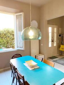 a dining room with a blue table and a window at Casa Milvio a Marina di Cecina by Zoom In Earth in Marina di Cecina +17 photos