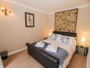 a bedroom with a bed with two towels at Rosemead in Moreton in Marsh