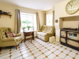 a living room with chairs and a table and a clock at Sarah Magees in Enniskillen