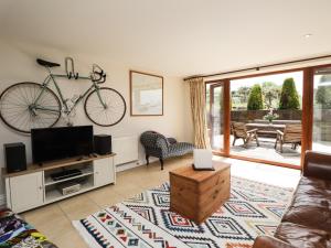 una sala de estar con una bicicleta colgada en la pared en Loose Farm Lodge, en Battle