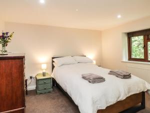 Un dormitorio con una gran cama blanca y una ventana en Loose Farm Lodge, en Battle