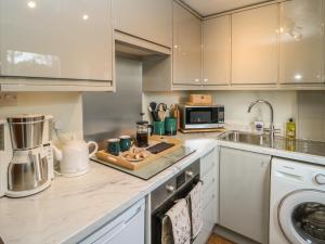 a kitchen with a sink and a stove top oven at Geraldene in Holmfirth