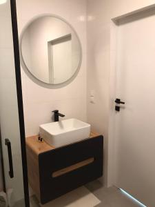 ブワディスワボボにあるApartament Harcerska-parking w garażu podziemnym w cenieの白い洗面台と鏡のあるバスルーム +12枚の写真