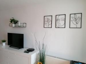 a living room with three framed drawings on the wall at Nexus Studio Deluxe in Miercurea-Ciuc