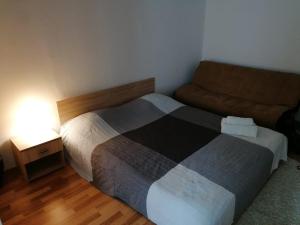 a small bedroom with a bed and a couch at Nexus Studio Deluxe in Miercurea-Ciuc
