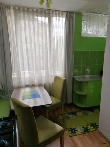 una piccola cucina con tavolo, sedie e finestra di Nexus Studio Deluxe a Miercurea-Ciuc