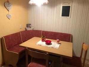 une table et un banc avec une table et un bol rouge dans l'établissement Ferienwohnung Irma, à Malschwitz