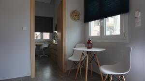 a kitchen with a table and chairs and a clock on the wall at Avli Luxury Apartment in Ierissos