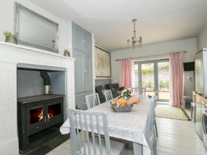 Troon Cottage في هونستنتون: غرفة معيشة مع طاولة مع موقد