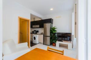 a living room with a table and a kitchen at Historic Center 1 in Coimbra