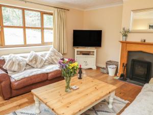 a living room with a couch and a table with flowers at Bryn Elsi in Betws-y-coed