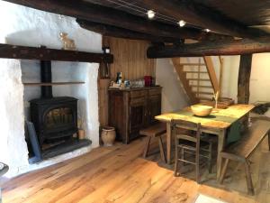kuchnia z kominkiem, stołem i kuchenką w obiekcie Mon Roc - Maison de montagne atypique avec vue w mieście La Grave