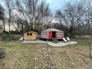 a yurt with a table and two chairs in a field at La Yurta de Gaia in San Lorenzo de El Escorial