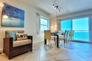 a living room with a dining room table and chairs at Holiday Villas III 703 in Clearwater Beach