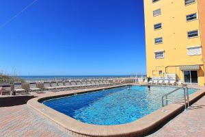 a large swimming pool next to a building and the ocean at Holiday Villas III 703 in Clearwater Beach