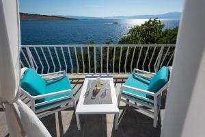 un balcón con 2 sillas y una mesa con vistas al agua en Apartments Viky en Kraljevica
