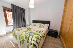sypialnia z łóżkiem z wytłoczoną pościelą w obiekcie APARTAMENTOS ONNIGHT w Maladze