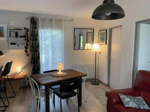 a living room with a table and chairs and a room at Chalet Mavalear naturiste La Jenny in Le Porge