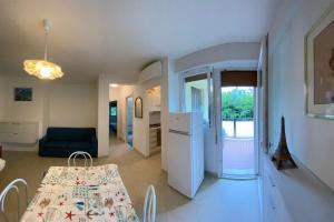 a kitchen and a dining room with a table and a couch at Sun Ste in Lido di Pomposa