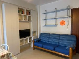 een blauwe bank in een kamer met een tv bij Sun Ste in Lido di Pomposa