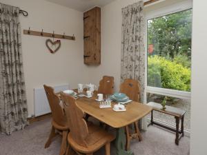 a dining room with a table and chairs and a window at Lucys cottage in Canonbie