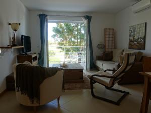 een woonkamer met een bank en een raam bij Gloria Maris Cabanas Gardens in Cabanas de Tavira