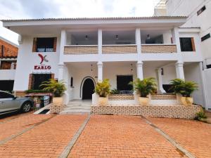 a white building with potted plants in front of it at Hotel Karlo By GHO Hoteles in Cali