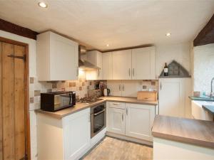 a kitchen with white cabinets and a microwave at Rustic Cottage in Windermere