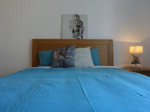 een slaapkamer met een blauw bed met een standbeeld van een man bij Gloria Maris Cabanas Gardens in Cabanas de Tavira +35 foto's