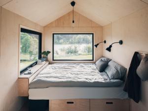 a bed in a tiny house with a window at Camp Saltstraumen-Elvegård in Bodø