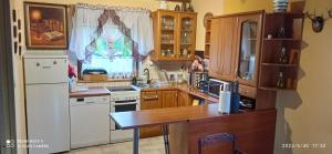a kitchen with wooden cabinets and a white refrigerator at Kaszuby Dom W Wielu in Wiele