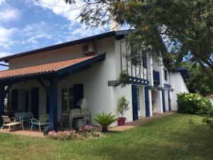 uma casa branca com acabamento azul e um quintal em Haritza em Anglet