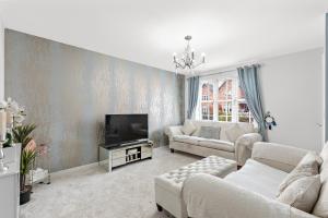 a living room with a couch and a tv at Silver Stag Properties, 3 bedroom luxury house in Coalville