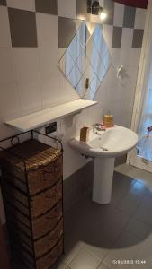een badkamer met een witte wastafel en een spiegel bij Little relax on the Garda lake in Toscolano Maderno
