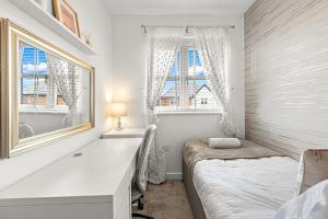 a bedroom with a bed and a desk and a window at Silver Stag Properties, 3 bedroom luxury house in Coalville