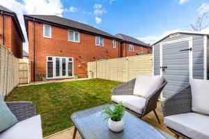 a small backyard with a patio furniture and a fence at Silver Stag Properties, 3 bedroom luxury house in Coalville