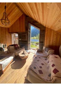 une grande chambre avec une grande fenêtre dans une cabine dans l'établissement Mon Roc - Maison de montagne atypique avec vue, à La Grave