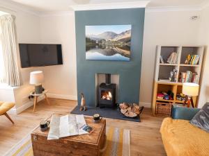 a living room with a fireplace and a tv at Pooley Howe in Keswick