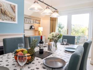 a dining room table with a bowl of fruit and wine glasses at Pooley Howe in Keswick