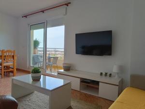 sala de estar con TV de pantalla plana en la pared en Casa Cumbremar en El Puerto de Mazarrón