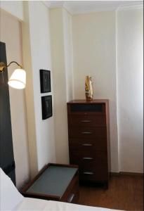 een slaapkamer met een dressoir en een lamp bij Αλσύλλιο - Alsillio studio apartments in Ierissos