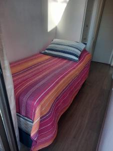 een bed met een kleurrijke deken erop bij Selma Apartment in Santiago