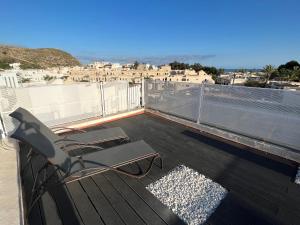 a balcony with a chair and a view of a city at La Terraza de Agua Amarga in Agua Amarga
