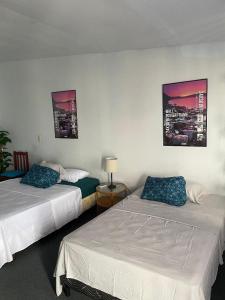 Habitación de hotel con 2 camas y 2 cuadros en la pared en Playa El Obispo B La Marea building La Libertad, en La Libertad