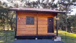 a small wooden cabin with a roof at Pousada Morro dos Pinhais in Urubici