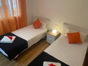 two beds in a small room with a night stand at Homely Apartments Mar 3 in Torrevieja +25 photos