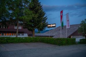 un edificio con due bandiere davanti di Hotel Swiss Views a Hemberg