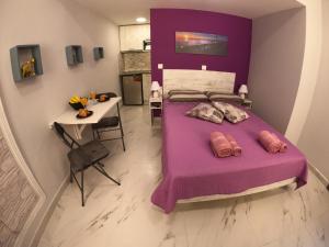 1 dormitorio con cama morada y mesa en MEMORIA, en Corfú