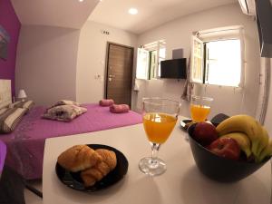un tavolo con un cesto di frutta e un bicchiere di succo d'arancia di MEMORIA a Città di Corfù