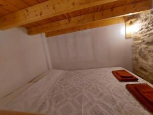 a bed in a room with a wooden ceiling at Ήλιος Πατσακης in Symi